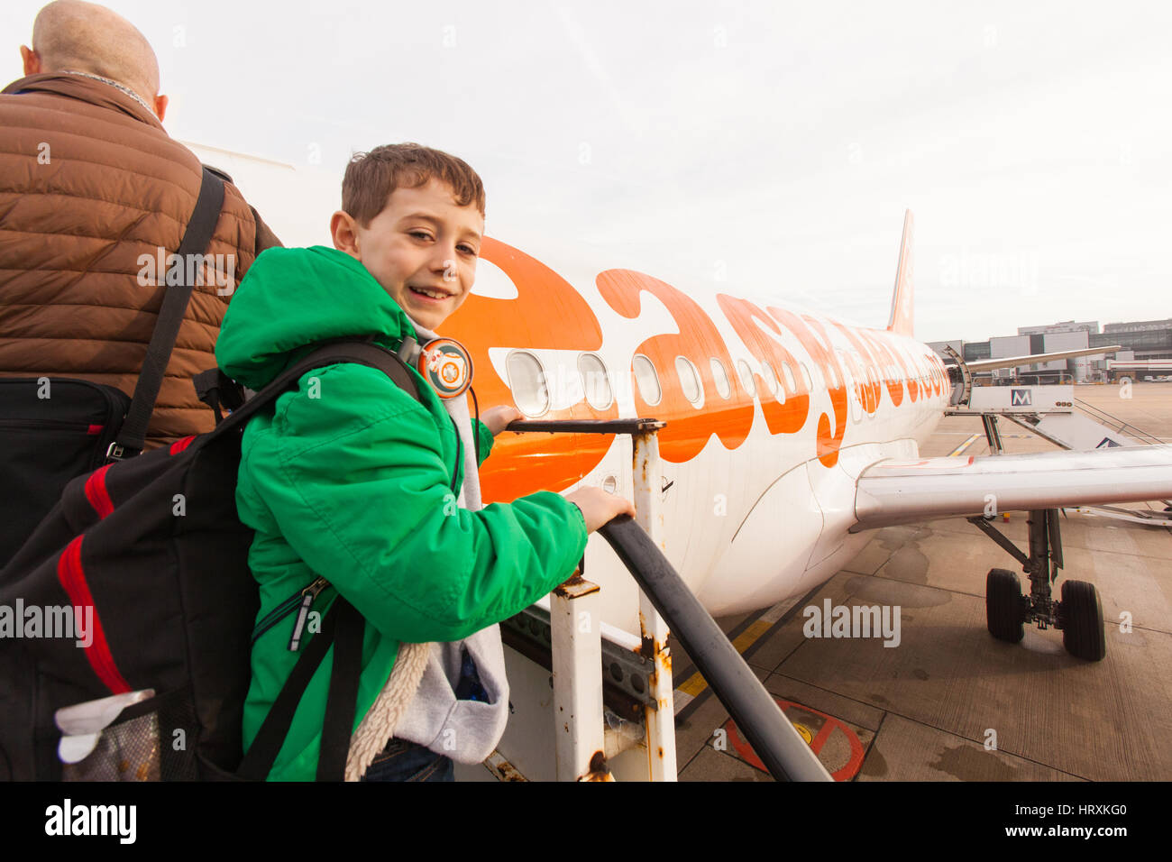 Seven year old boy excitedly boarding a Easyjet flight at London Gatwick airport. Stock Photo