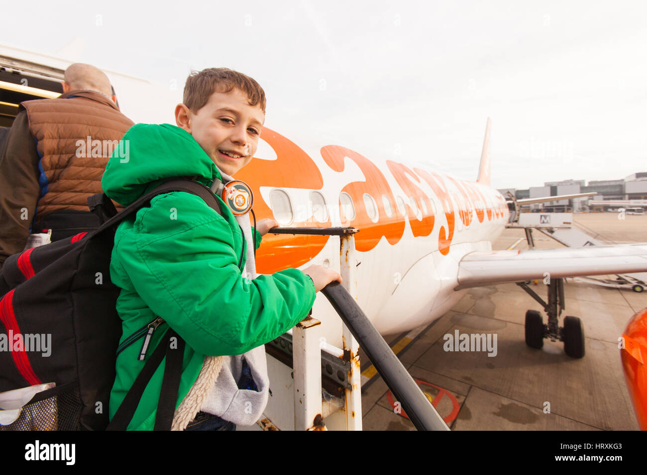 Seven year old boy excitedly boarding a Easyjet flight at London Gatwick airport. Stock Photo