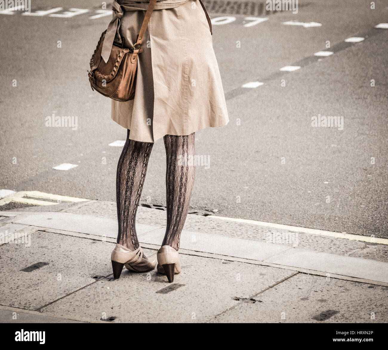 A girl in stockings crossing London street Stock Photo