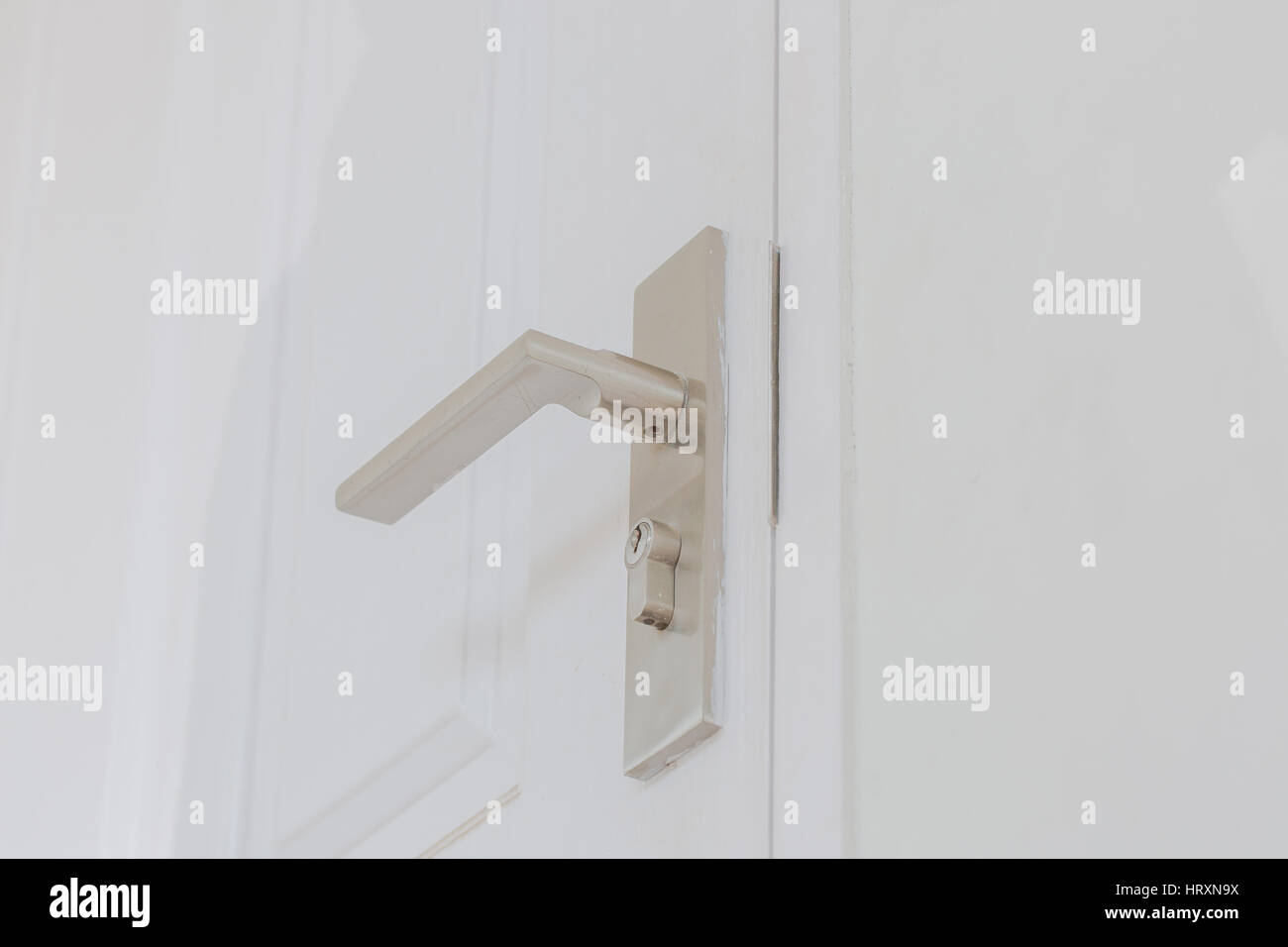 Metallic knob (locksmith) on white door horizontal. Stock Photo