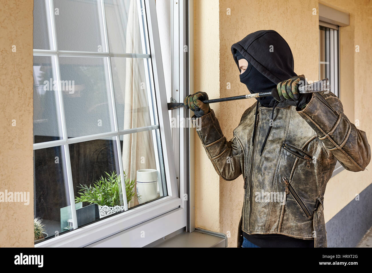 Burglar trying to break into a house with a crowbar Stock Photo Alamy
