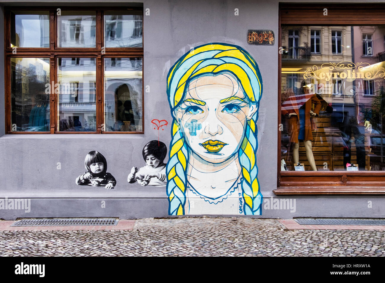 Berlin, Prenzlauer Berg. Street scene, Cyroline Upmarket clothing shop exterior and El Bocho street art Stock Photo