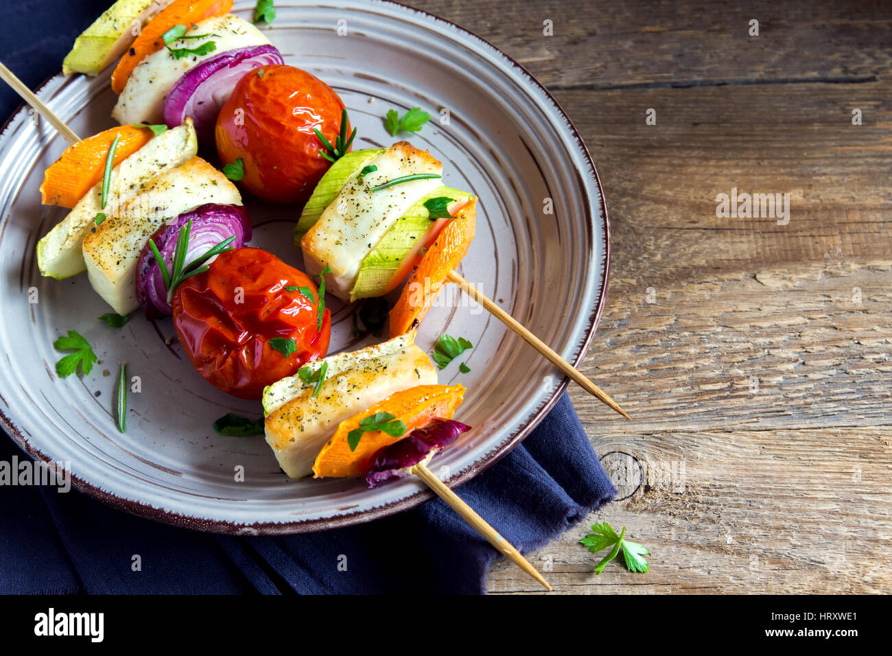 Halloumi cheese and vegetables grilled skewers on plate with spices and herbs close up healthy