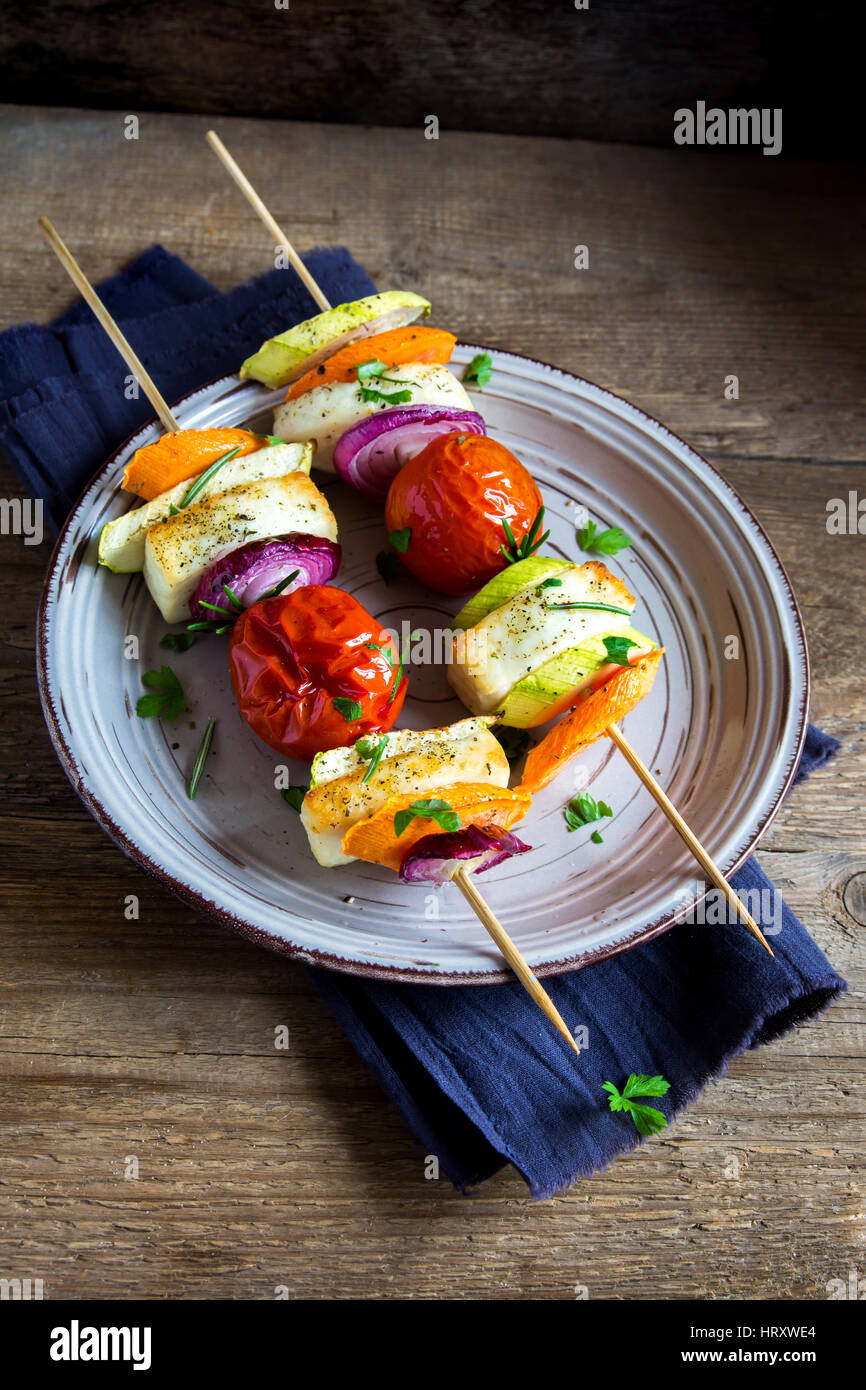 Halloumi cheese and vegetables grilled skewers on plate with spices and herbs close up healthy