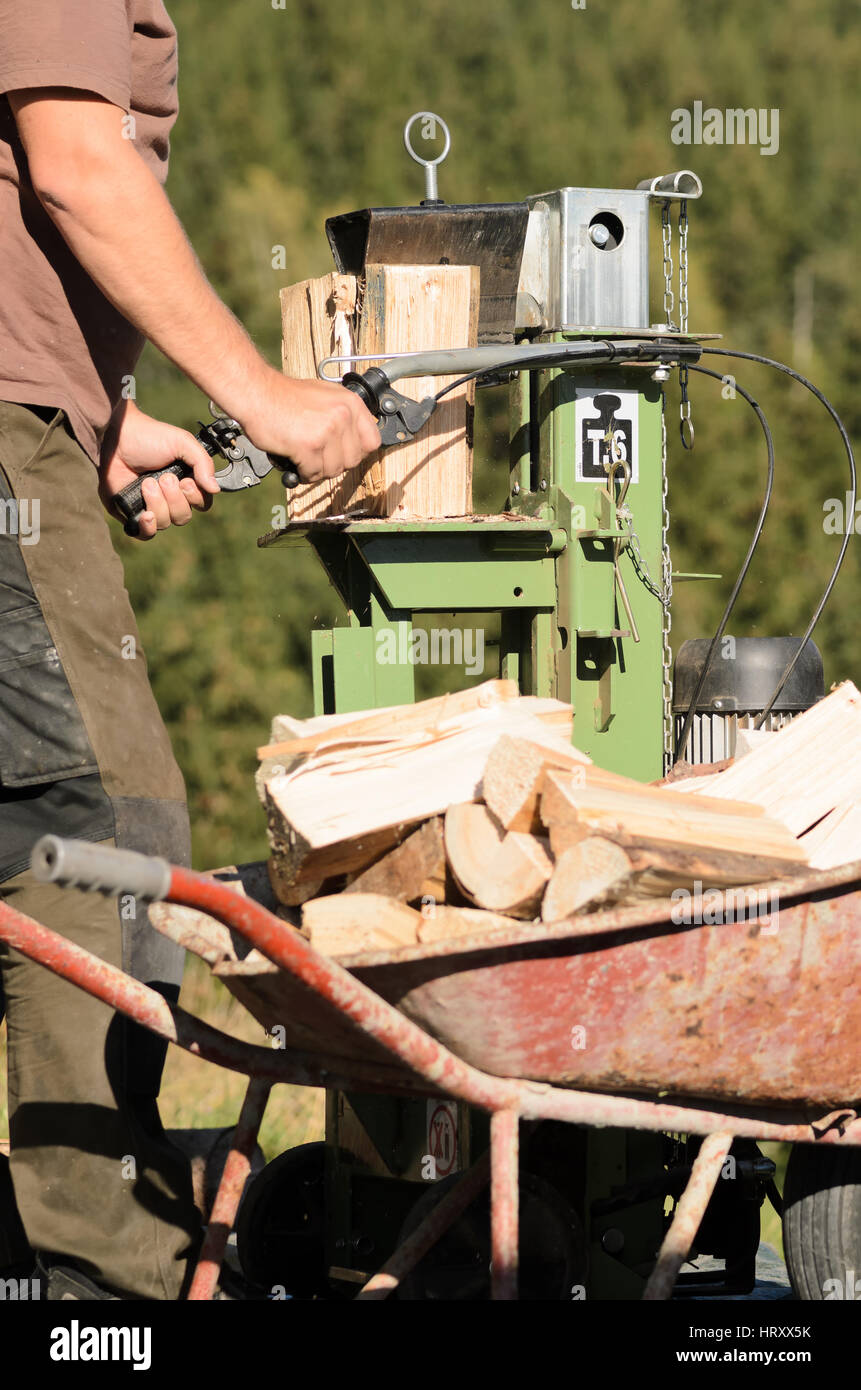 Man is using a electric log splitter Stock Photo