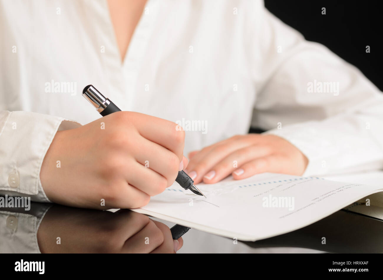 Close up of woman signing a document or a contract Stock Photo