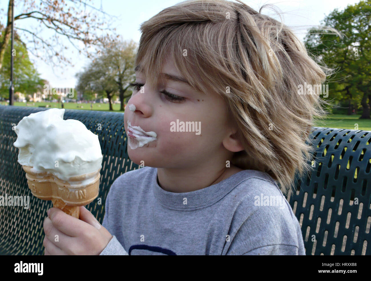 A boy makes a mess of eating an ice cream Stock Photo