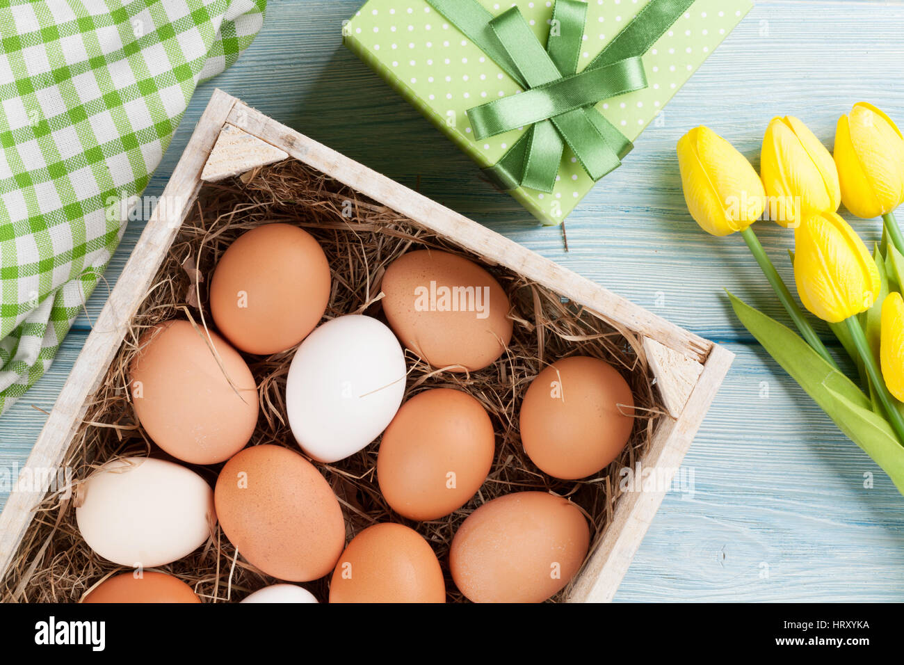 Easter eggs and yellow tulips over wooden background Stock Photo - Alamy