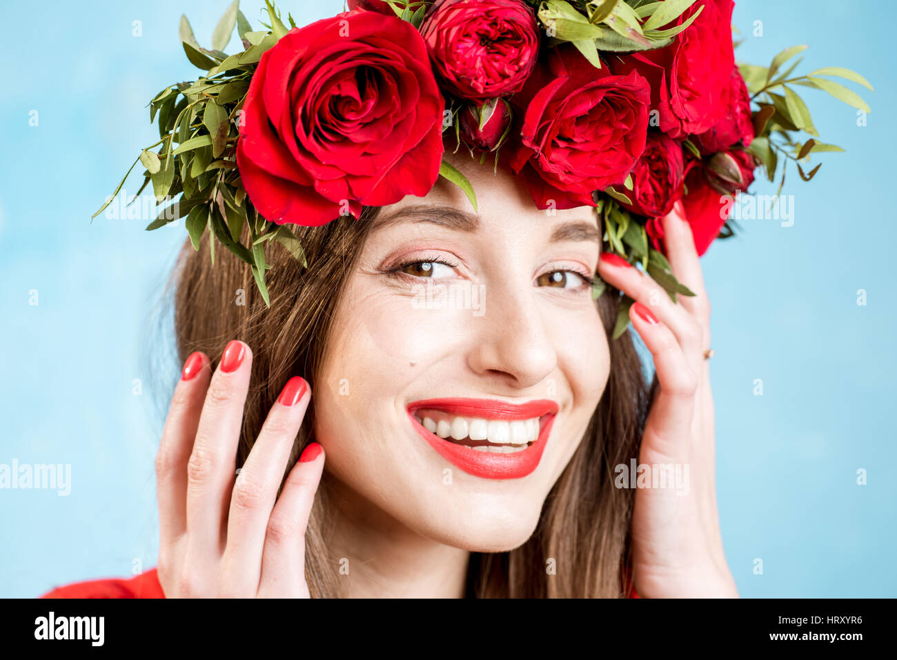 Close-up portrait of a beautiful woman in red dress with wreath made of ...
