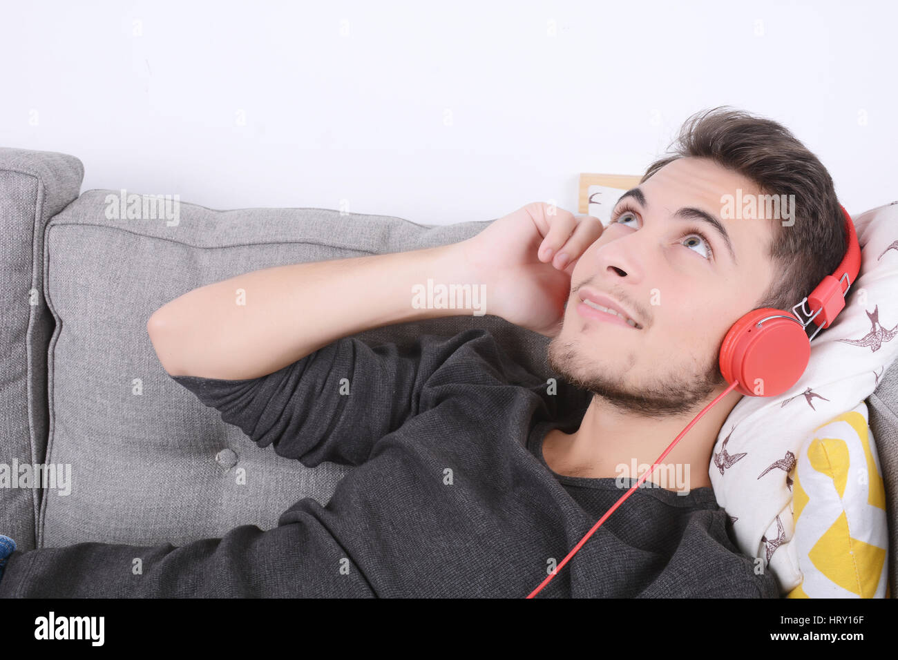 Attractive young man listening to music with headphones and relaxed on ...