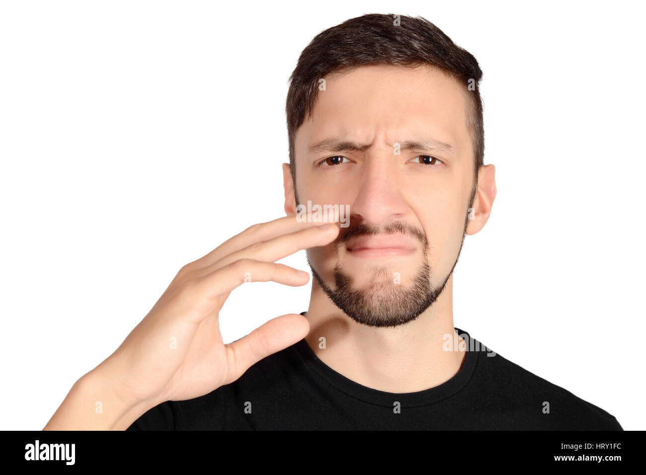 Portrait of young man holding his nose against a bad smell. Isolated white background. Stock Photo