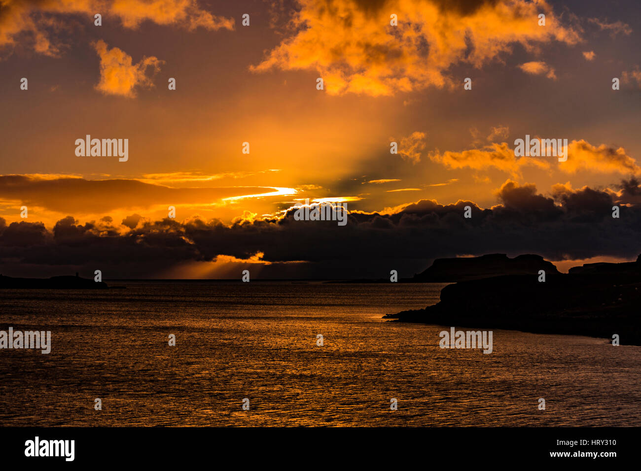 Sunset with crepuscular light across Loch Beag, Isle of Skye, looking out to Ullinish Point, Bracdale Point, Ardtreck Point and Isle Oronsay Stock Photo