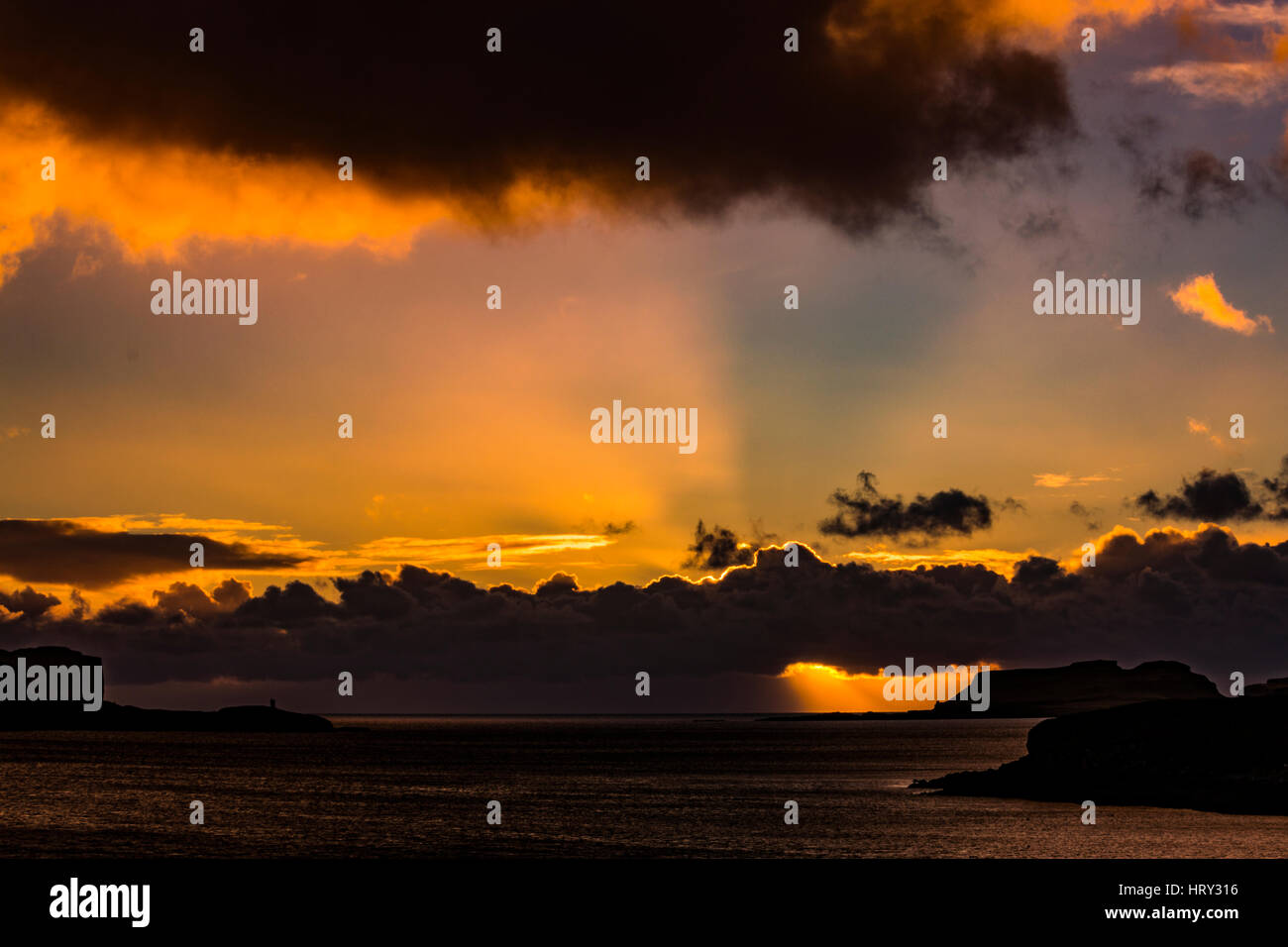 Sunset with crepuscular light across Loch Beag, Isle of Skye, looking out to Ullinish Point, Bracdale Point, Ardtreck Point and Isle Oronsay Stock Photo
