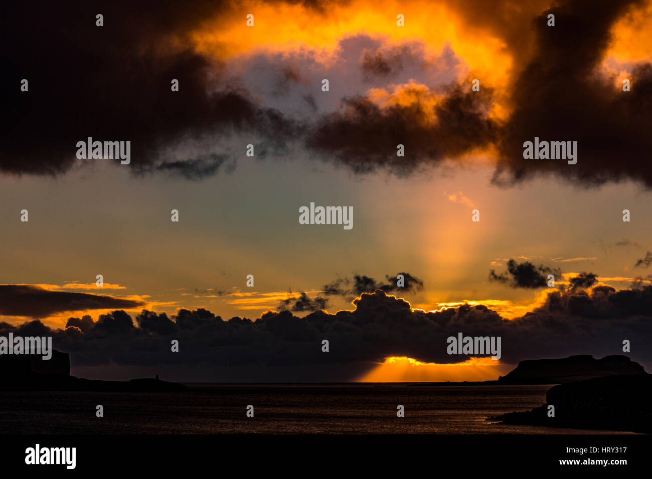 Sunset with crepuscular light across Loch Beag, Isle of Skye, looking out to Ullinish Point, Bracdale Point, Ardtreck Point and Isle Oronsay Stock Photo