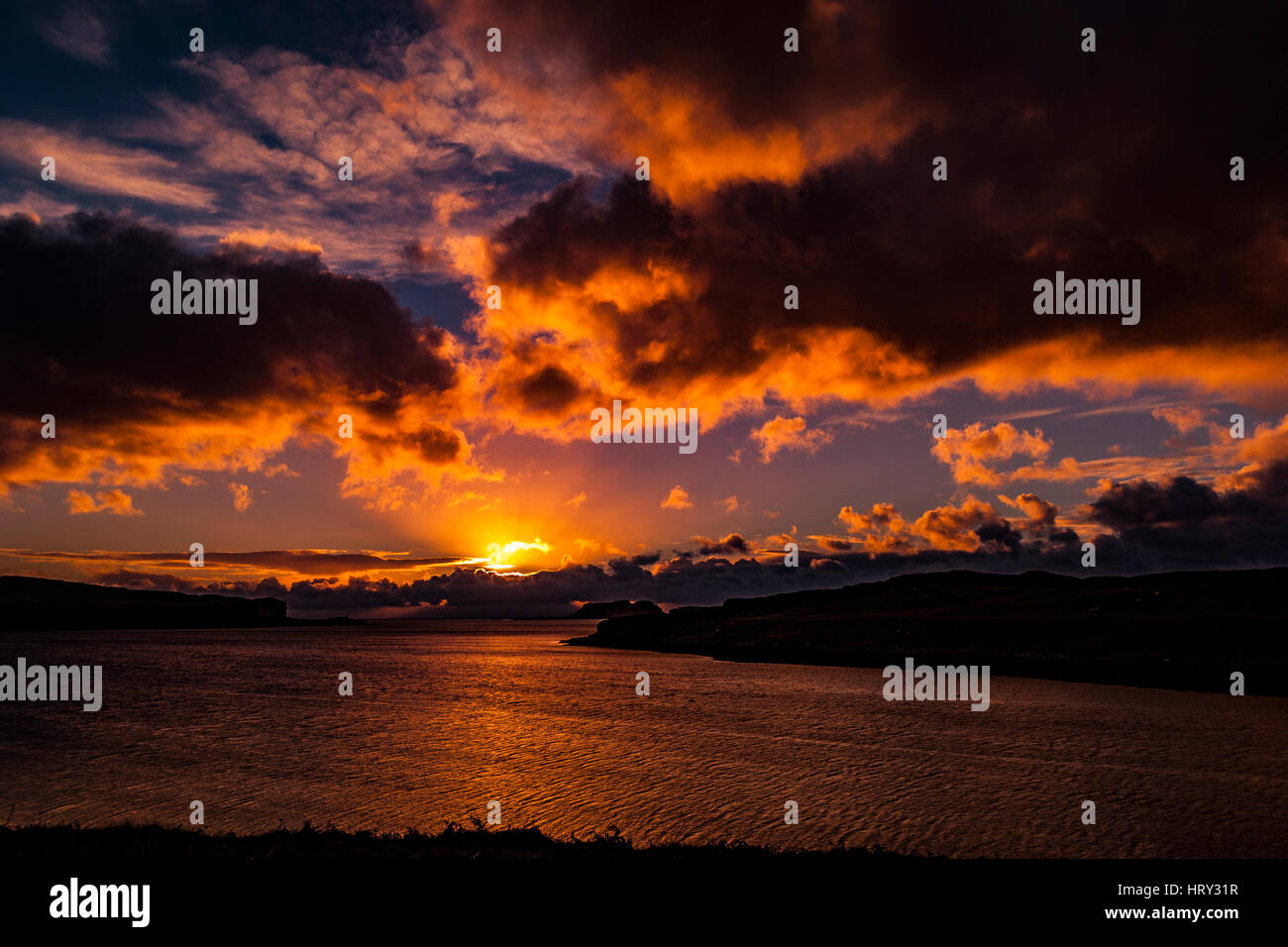 Sunset with crepuscular light across Loch Beag, Isle of Skye, looking out to Ullinish Point, Bracdale Point, Ardtreck Point and Isle Oronsay Stock Photo