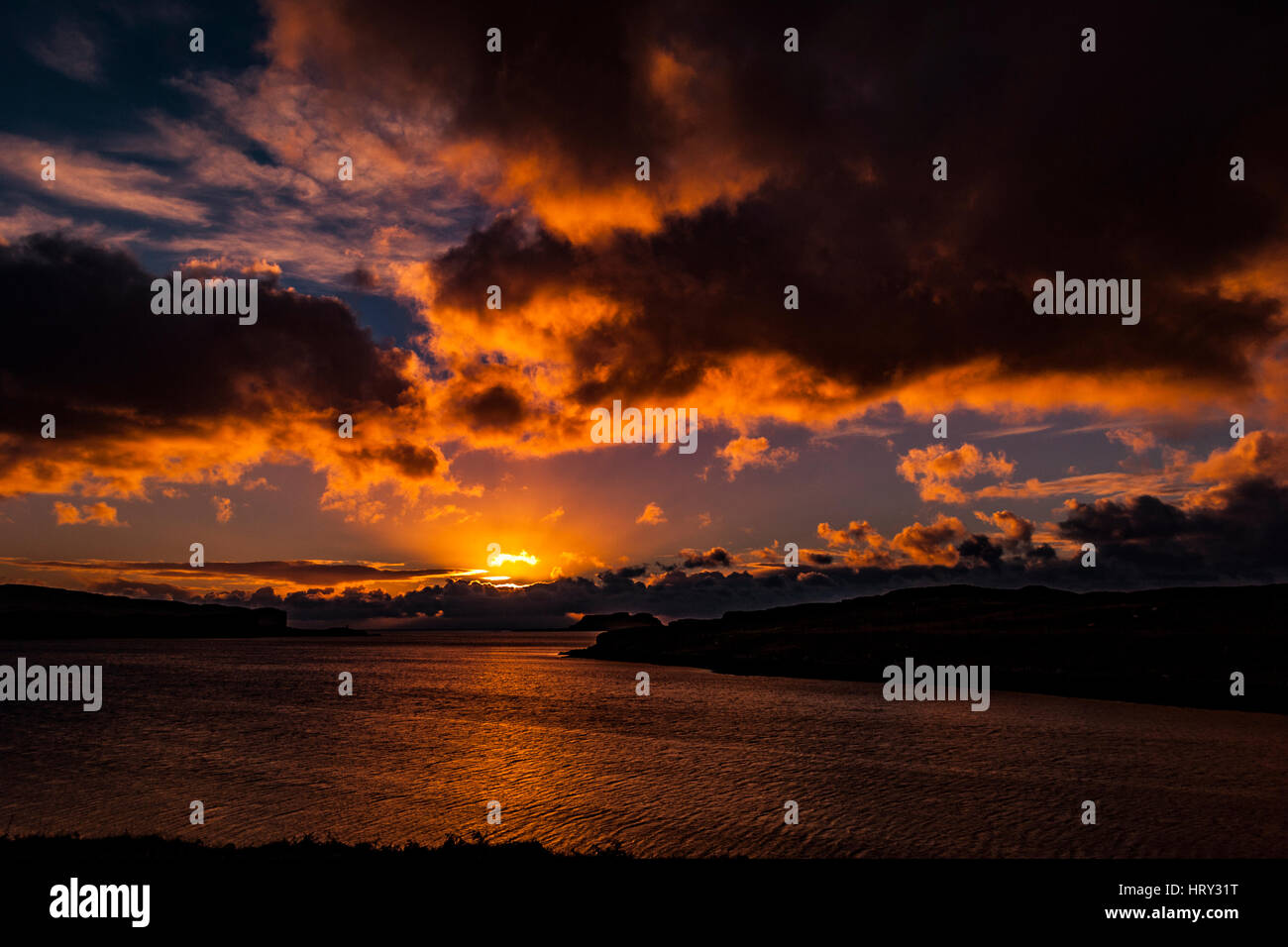 Sunset with crepuscular light across Loch Beag, Isle of Skye, looking out to Ullinish Point, Bracdale Point, Ardtreck Point and Isle Oronsay Stock Photo