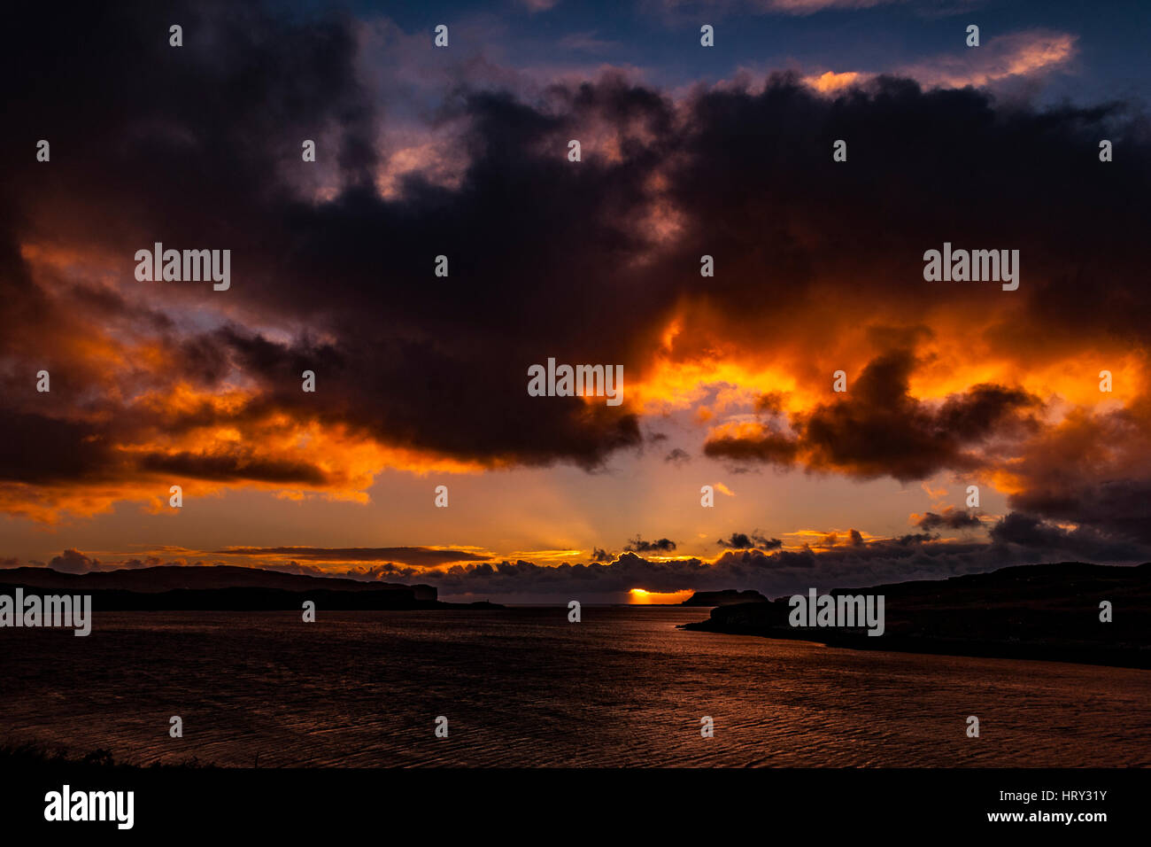 Sunset with crepuscular light across Loch Beag, Isle of Skye, looking out to Ullinish Point, Bracdale Point, Ardtreck Point and Isle Oronsay Stock Photo