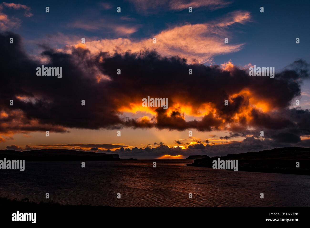 Sunset with crepuscular light across Loch Beag, Isle of Skye, looking out to Ullinish Point, Bracdale Point, Ardtreck Point and Isle Oronsay Stock Photo