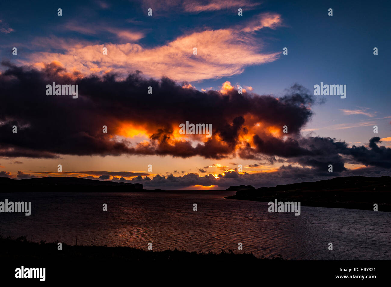 Sunset with crepuscular light across Loch Beag, Isle of Skye, looking out to Ullinish Point, Bracdale Point, Ardtreck Point and Isle Oronsay Stock Photo