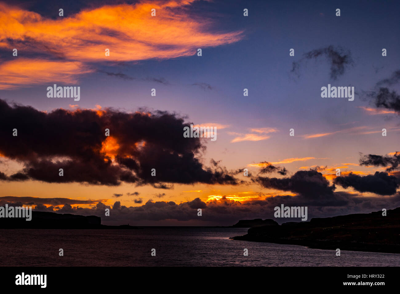 Sunset with crepuscular light across Loch Beag, Isle of Skye, looking out to Ullinish Point, Bracdale Point, Ardtreck Point and Isle Oronsay Stock Photo