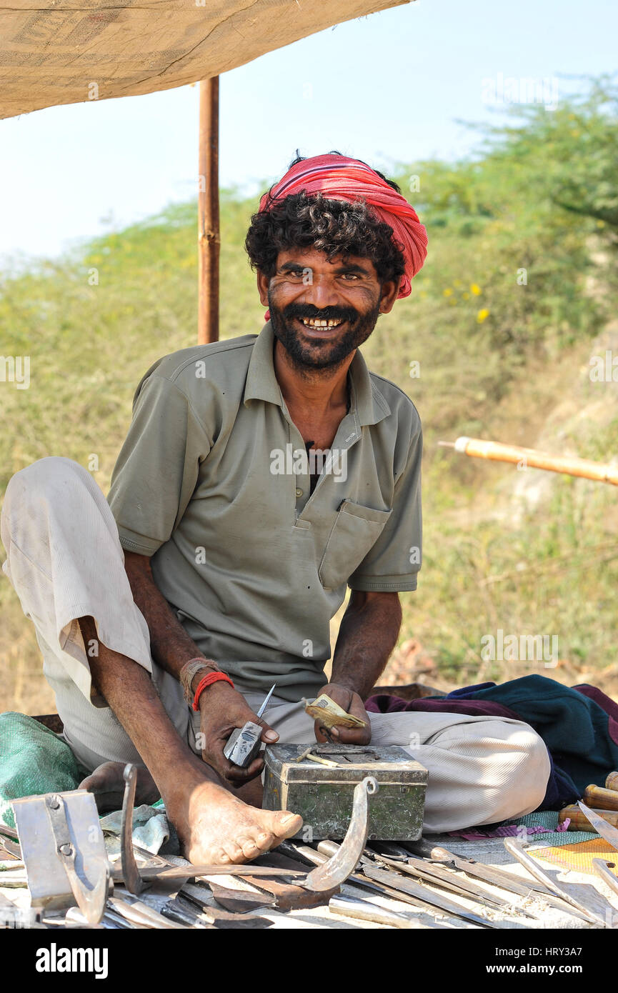 Smiling man at his ironware stall, Baneshwar Mela Stock Photo