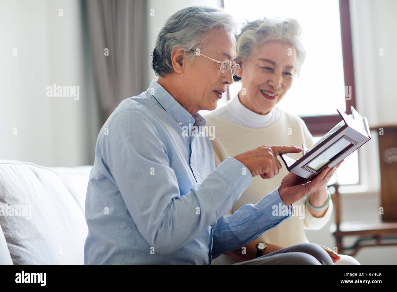 Couple looking photo album talking hi-res stock photography and images ...