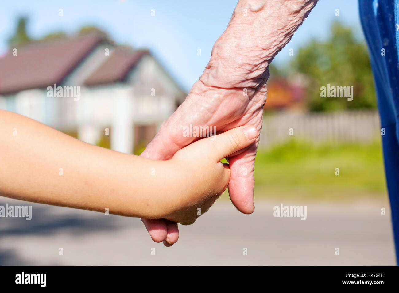 grandmother taking hand of young child, concept Stock Photo