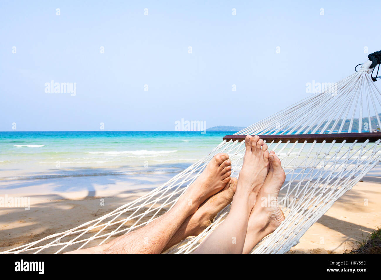 family holidays on the beach, feet of couple in hammock, relaxation background Stock Photo