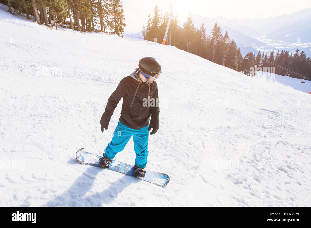 winter holidays, young man on snowboard in alpine mountains Stock Photo