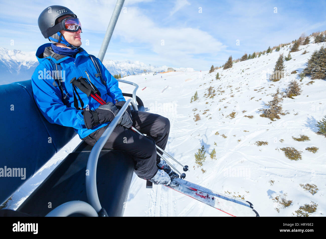 happy skier on ski lift elevator in winter mountains Stock Photo