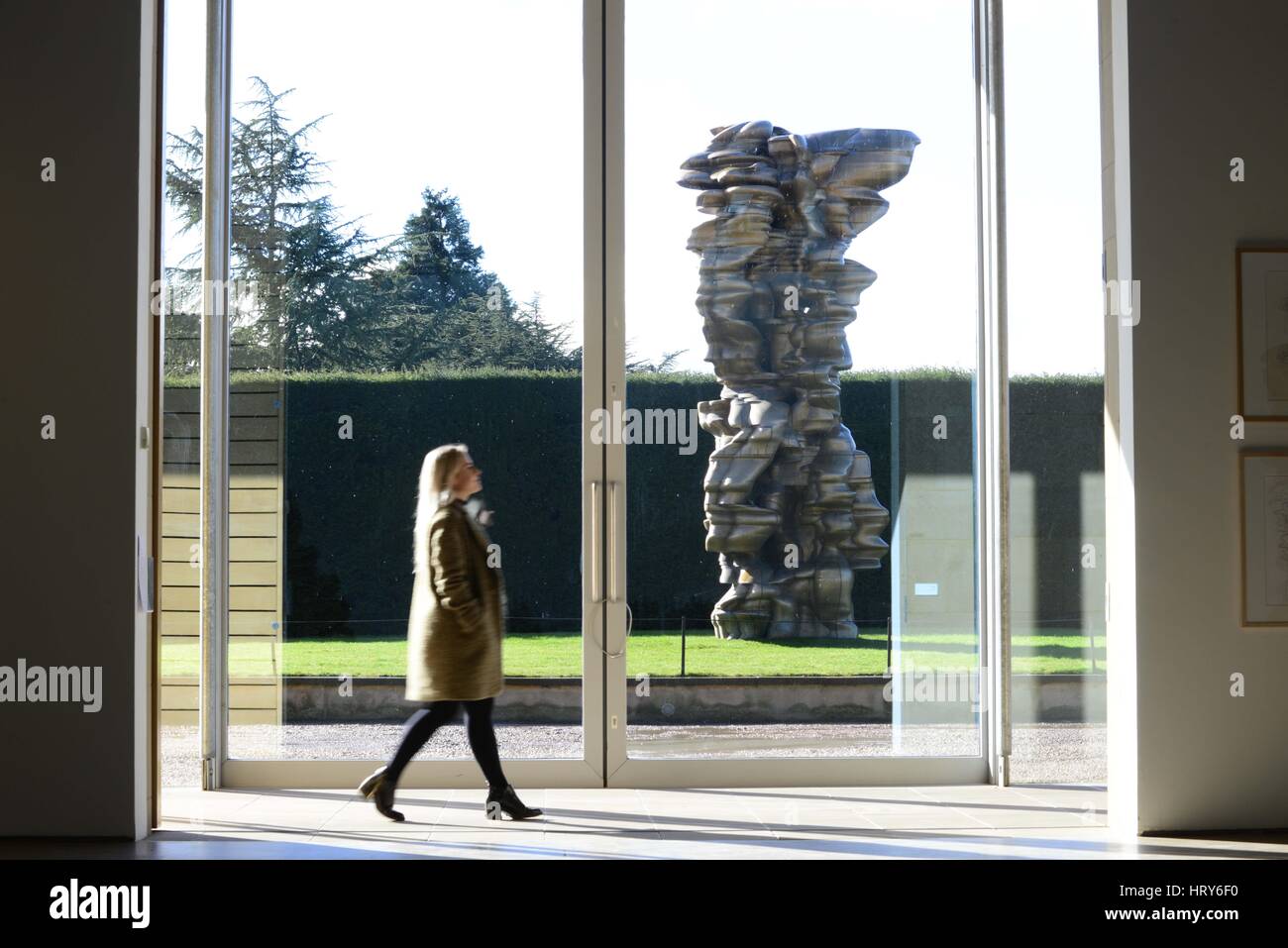 A Yorkshire Sculpture Park visitor walks past a sculpture named 'Mean Average' by sculptor Tony Cragg. The exhibition 'A Rare Category of Objects' by  Stock Photo