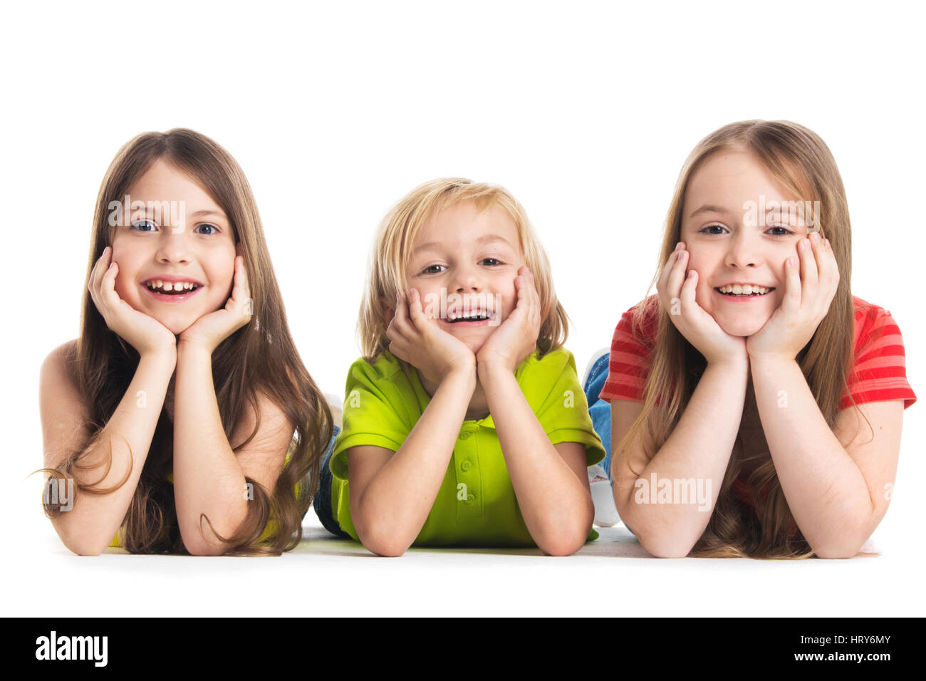 Happy smiling three children in colorful clothes laying on floor isolated on white background Stock Photo
