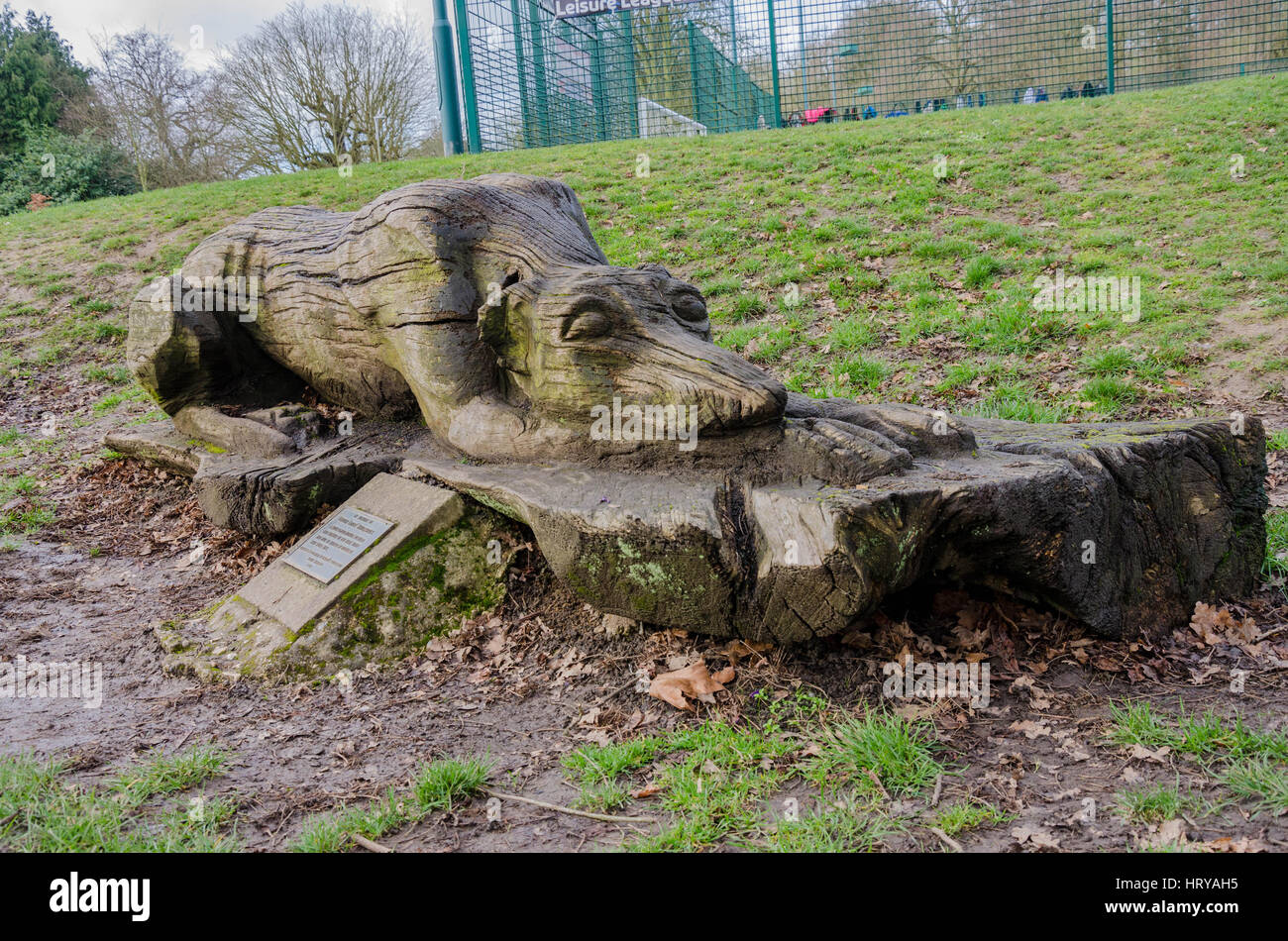 A wooden carving of a sleeping dog in Prospect Park in Reading stands as a memorial to a departed colleague. Stock Photo