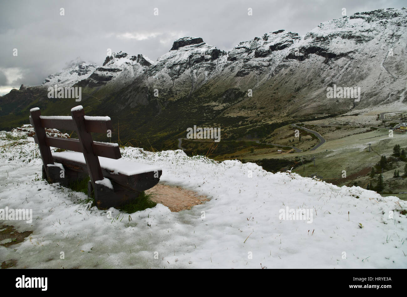 Passo Pordoi: bench covered by the first snow of the season on the Dolomiti mountains Stock Photo