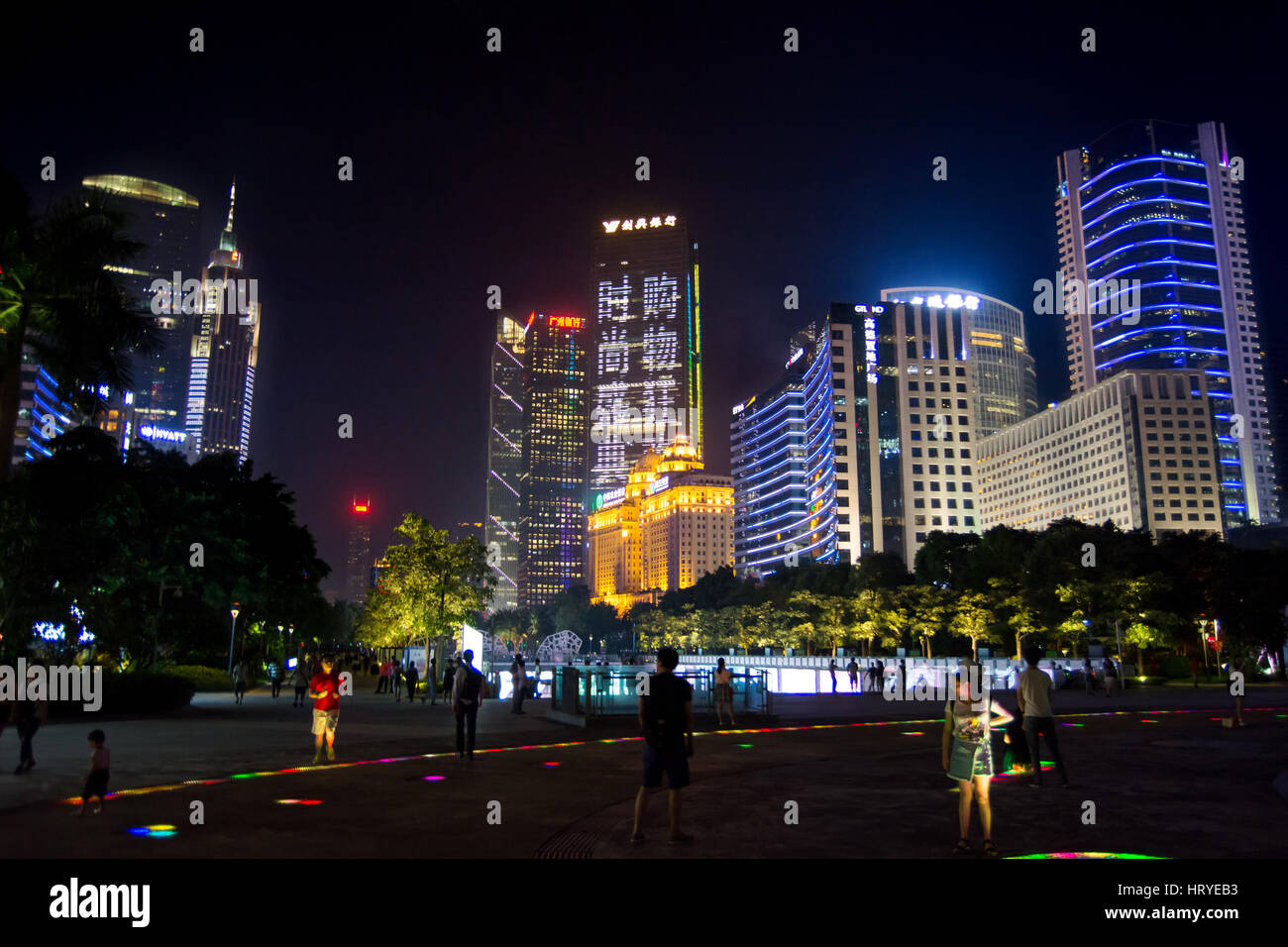GUANGZHOU, CHINA - SEPTEMBER 13, 2016: Guangzhou modern central city district with people walking in illuminated path, night view Stock Photo