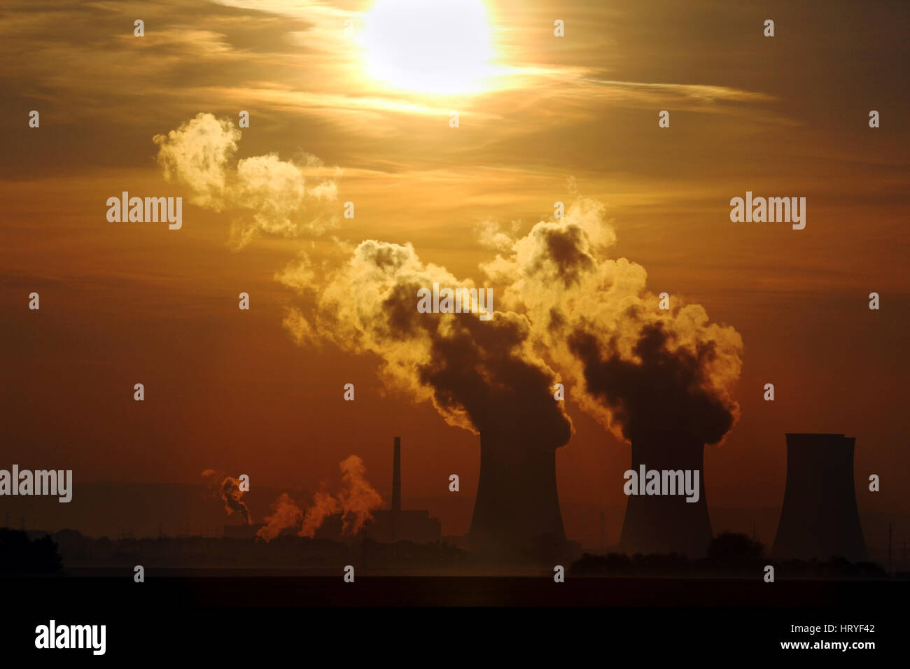 sun set over smoking nuclear power plant Stock Photo