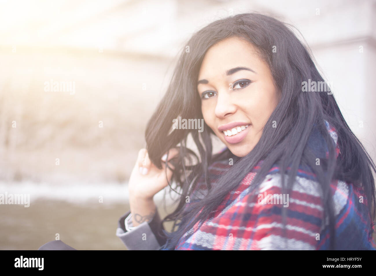 Beautiful confident young woman with african somatic traits outside in the city, concept of modern, emancipated woman, mixed races, contemporary lifes Stock Photo