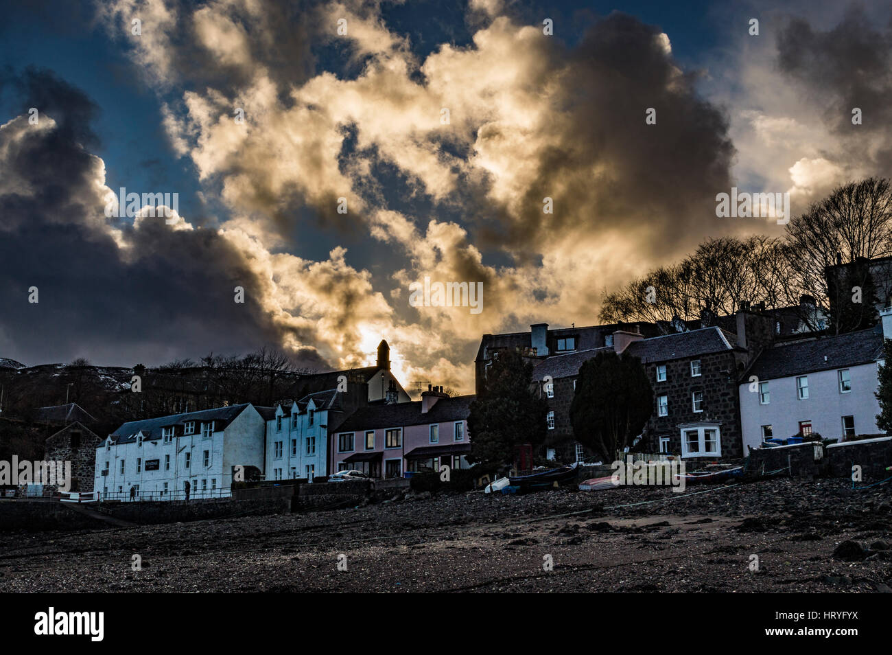 Sunset reflecting off clouds above Portree, March 2017, looking from the shore of Portree Harbolur, Isle of Skye, Scotland, UK Stock Photo