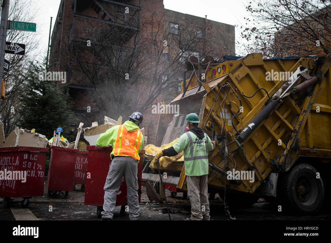 Laborers for a demolition company load structural material taken out of