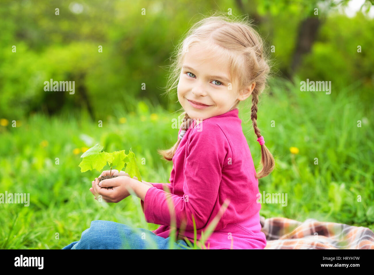 Little girl holding little green plant in her hands Stock Photo - Alamy
