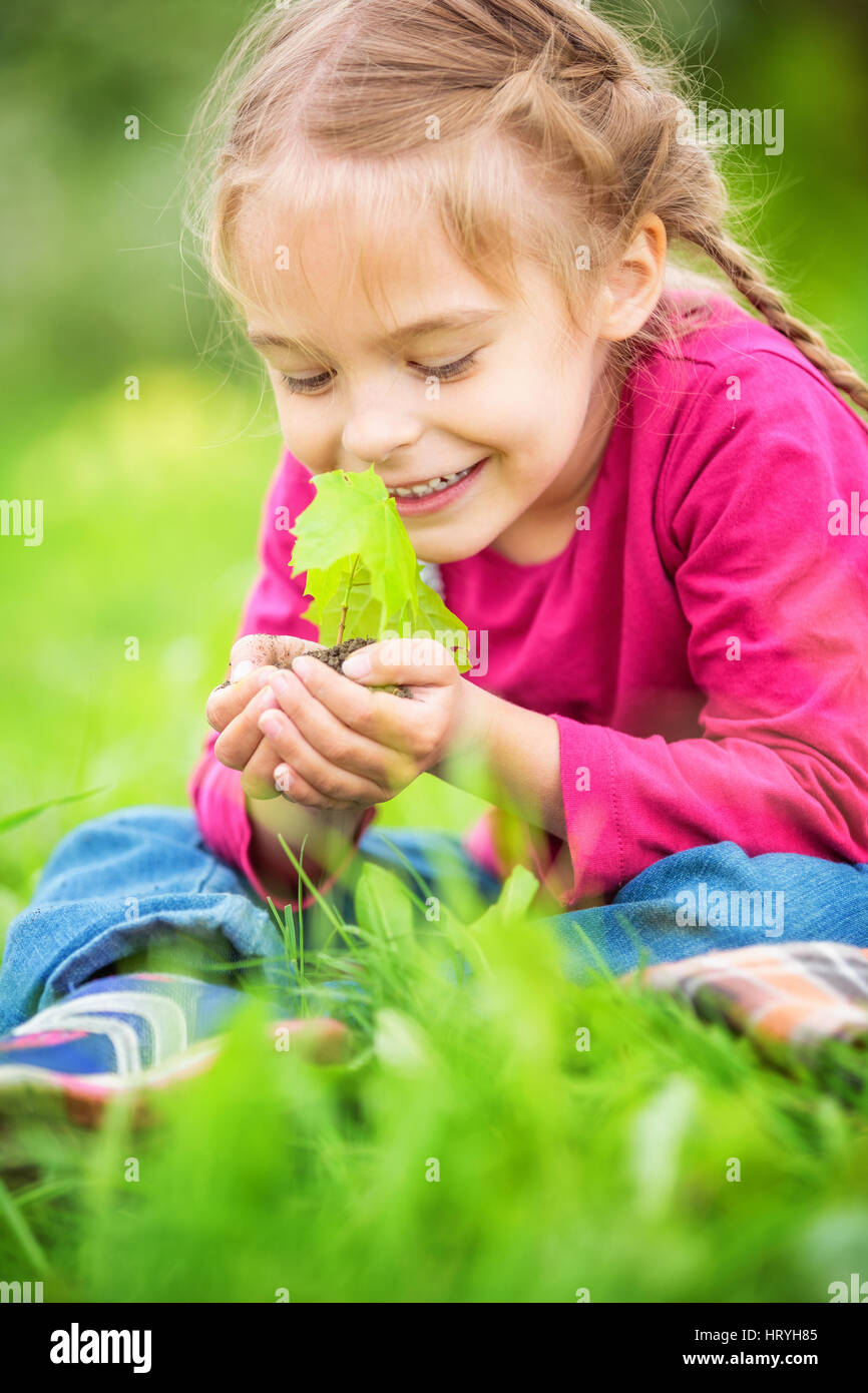 Little girl holding little green plant in her hands Stock Photo - Alamy