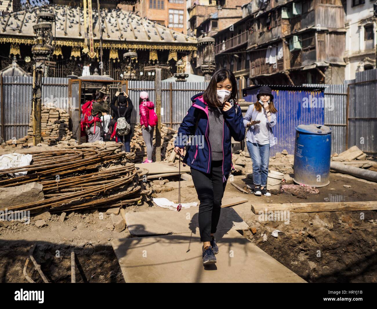 Kathmandu, Central Development Region, Nepal. 5th Mar, 2017. Tourists walk through an empty lot being rebuilt after the 2015 earthquake. Much of Kathmandu is now a construction site because of rebuilding two years after the earthquake of 25 April 2015 that devastated Nepal. In some villages in the Kathmandu valley workers are working by hand to remove ruble and dig out destroyed buildings. About 9,000 people were killed and another 22,000 injured by the earthquake. The epicenter of the earthquake was east of the Gorka district. Credit: Jack Kurtz/ZUMA Wire/Alamy Live News Stock Photo