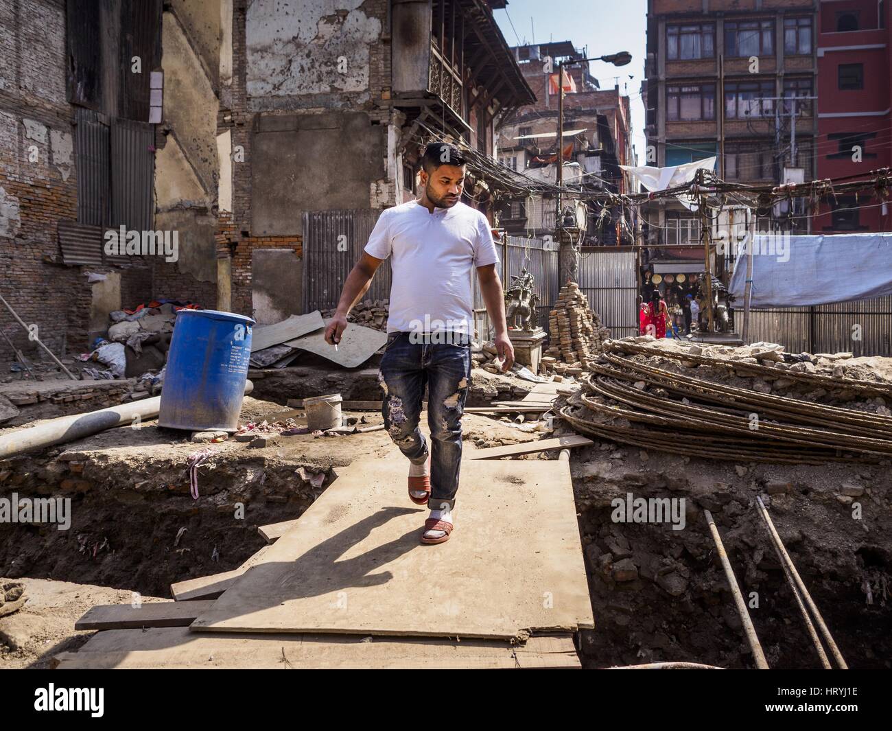 Kathmandu, Central Development Region, Nepal. 5th Mar, 2017. A Nepali man walks through an empty lot being rebuilt after the 2015 earthquake. Much of Kathmandu is now a construction site because of rebuilding two years after the earthquake of 25 April 2015 that devastated Nepal. In some villages in the Kathmandu valley workers are working by hand to remove ruble and dig out destroyed buildings. About 9,000 people were killed and another 22,000 injured by the earthquake. The epicenter of the earthquake was east of the Gorka district. Credit: Jack Kurtz/ZUMA Wire/Alamy Live News Stock Photo