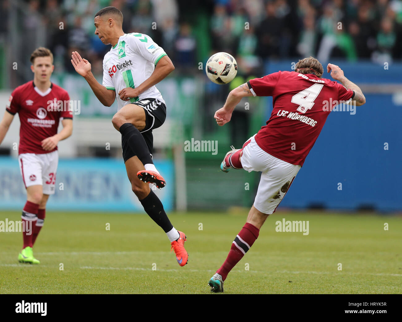 Fuerth, Germany. 5th Mar, 2017. Fuerth's Mathis Bolly (c) and Nuremberg's Dave Bulthuis (r) in action during the 2nd Bundesliga soccer match between SpVgg Greuther Fuerth and 1. FC Nuremberg at the Stadion am Laubenweg in Fuerth, Germany, 5 March 2017. (EMBARGO CONDITIONS - ATTENTION: Due to the accreditation guidlines, the DFL only permits the publication and utilisation of up to 15 pictures per match on the internet and in online media during the match.) Photo: Daniel Karmann/dpa/Alamy Live News Stock Photo