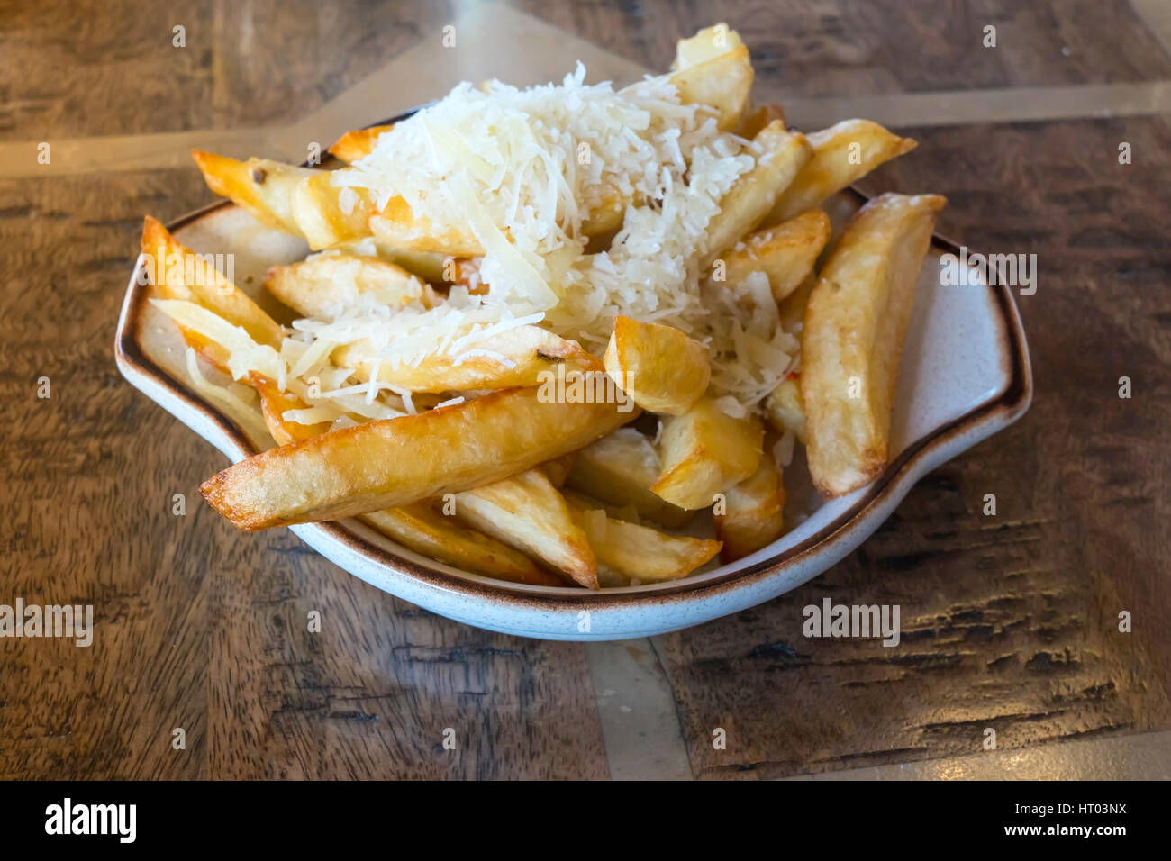 Side dish of Cheesy Chips fried chipped potatoes sprinkled with grated