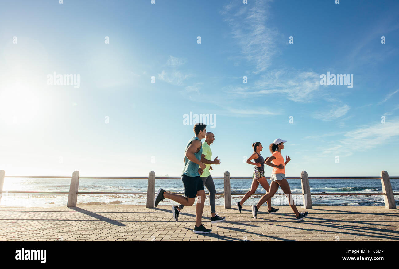 Portrait of young runners on the sea front path along the shoreline