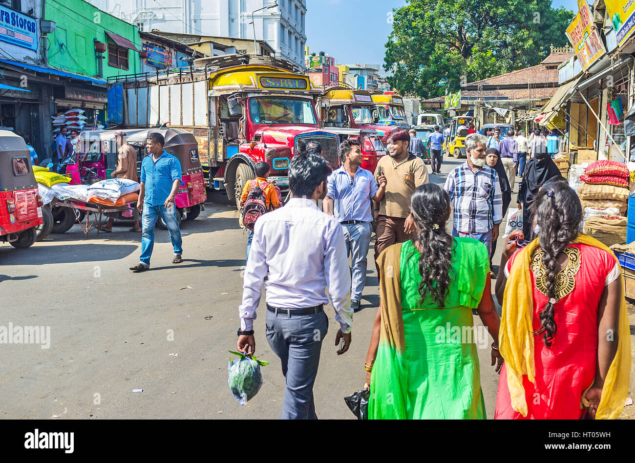 COLOMBO, SRI LANKA - DECEMBER 6, 2016: The crowded street in Pettah with colorful trucks, parked along the shops, on December 6 in Colombo. Stock Photo