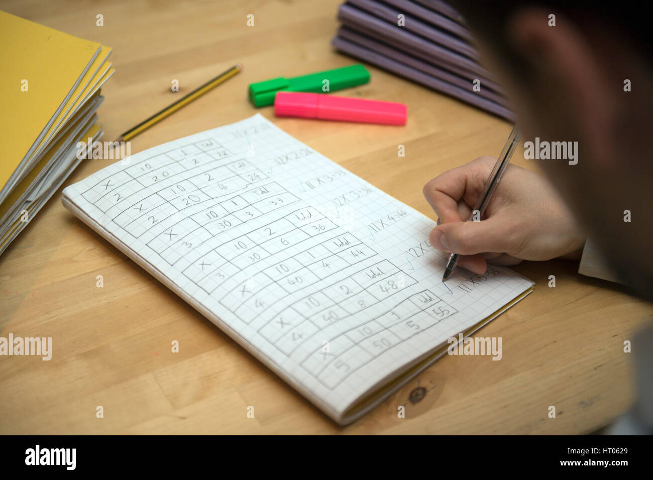 A primary school teacher marking a pupil's maths homework. Stock Photo