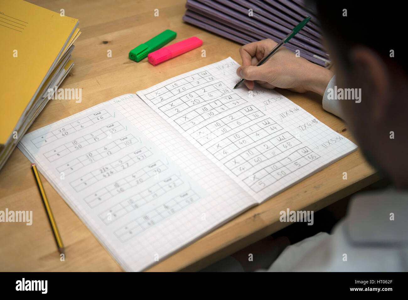 A primary school teacher marking a pupil's maths homework. Stock Photo