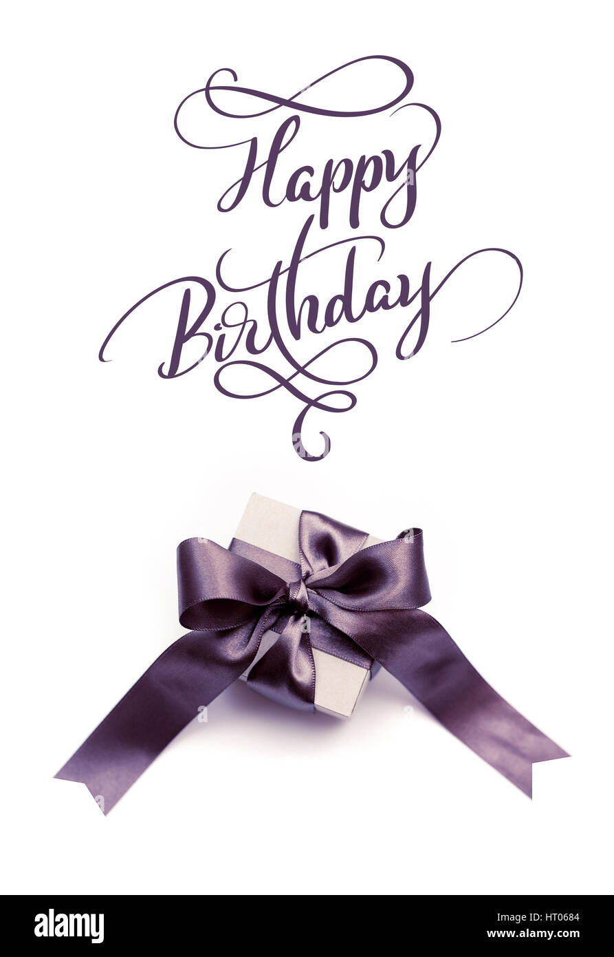 Gift box with brown bow on a white background and text Happy Birthday. Calligraphy lettering Stock Photo